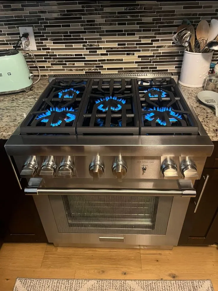 Freestanding gas range with oven and burners.